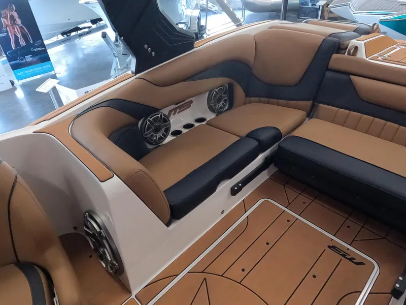 Slide: The Image of 2023 MB B52 Alpha boat interior with tan and black seating, speakers, and cup holders. - 14