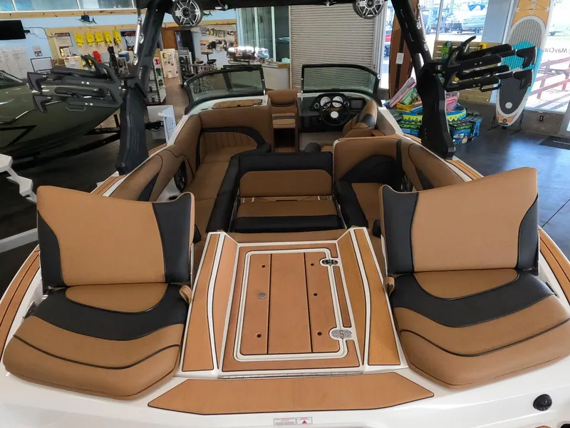 Slide: The Image of 2023 MB B52 Alpha boat interior with tan and black seating, wood flooring, and modern dashboard. - 9