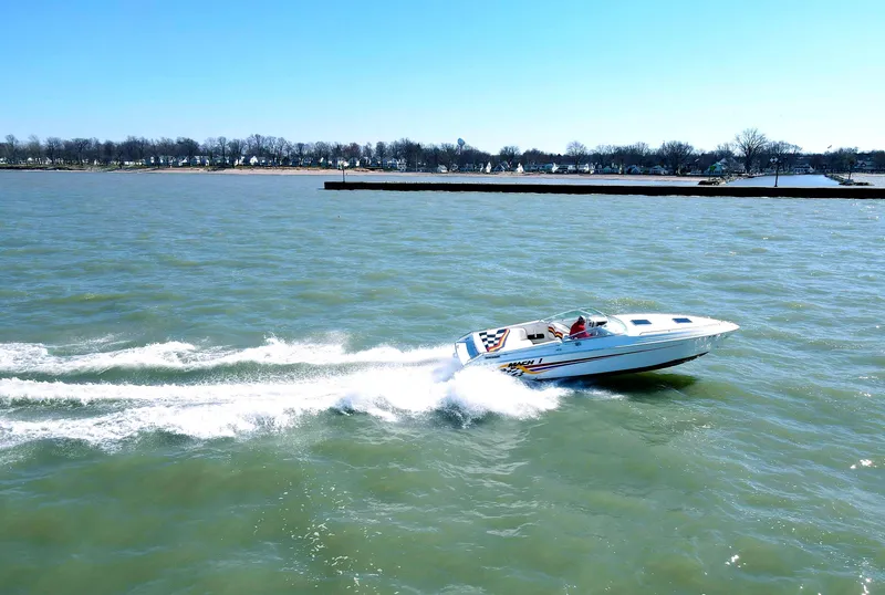 The Image of 1999 Baha Cruisers 290 Mach 1 speedboat cruising on a lake. - 0