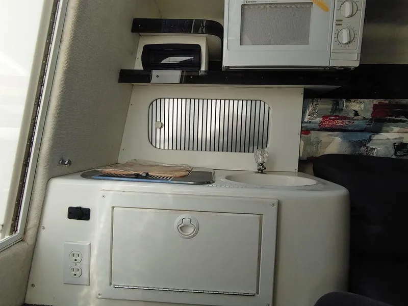 Slide: The Image of Compact kitchen area in a 1999 Baha Cruisers 290 Mach 1 boat with microwave and sink. - 10
