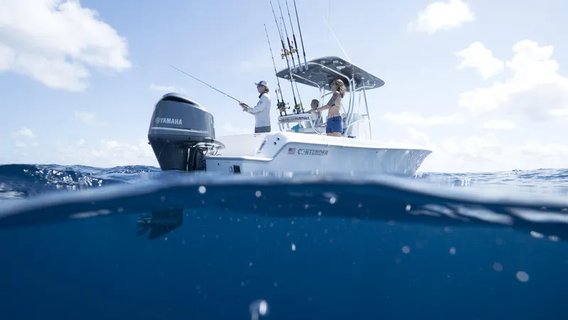 Slide: The Image of 2024 Contender 24S boat with Yamaha engine on open water, people fishing. - 1