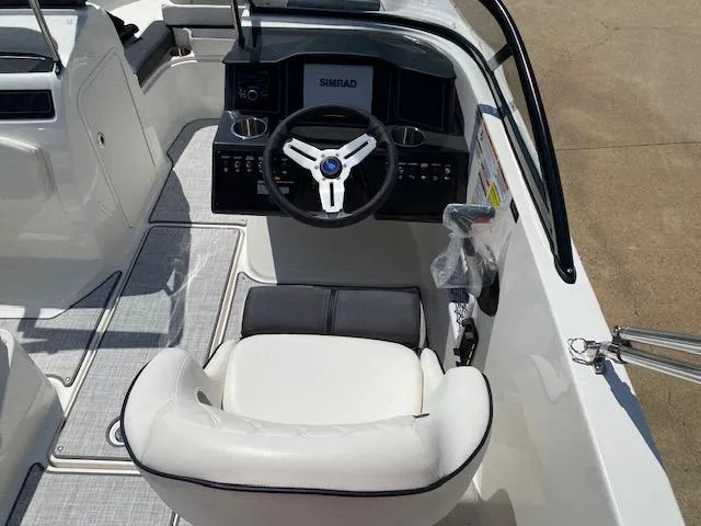 Slide: The Image of 2024 Bayliner VR5 boat cockpit with steering wheel and seating. - 18