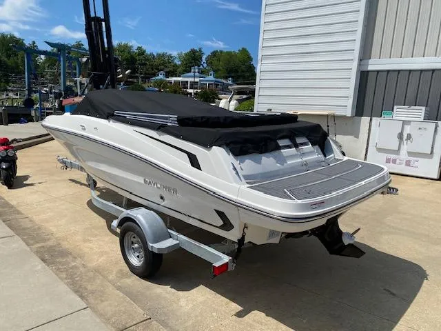 Slide: The Image of 2024 Bayliner VR5 boat on trailer, covered and parked outdoors. - 2