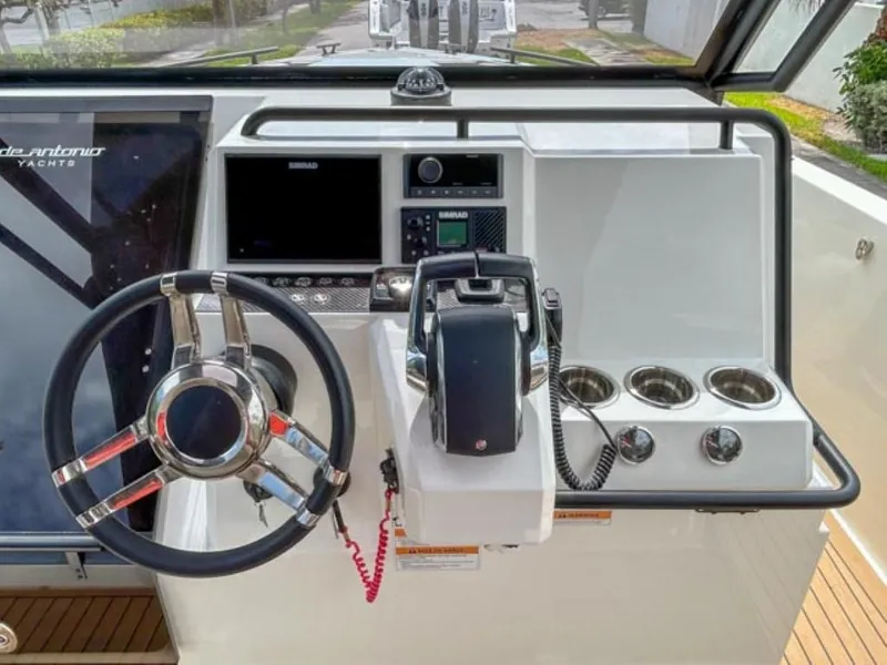 Slide: The Image of 2024 De Antonio Yachts D28 Xplorer helm station with steering wheel, controls, and cup holders. - 10