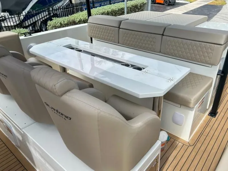 Slide: The Image of 2024 De Antonio Yachts D28 Xplorer interior with beige seating and white table. - 18