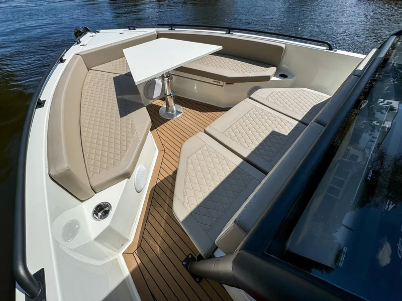 Slide: The Image of 2024 De Antonio Yachts D28 Xplorer interior with beige seating and table on water. - 22