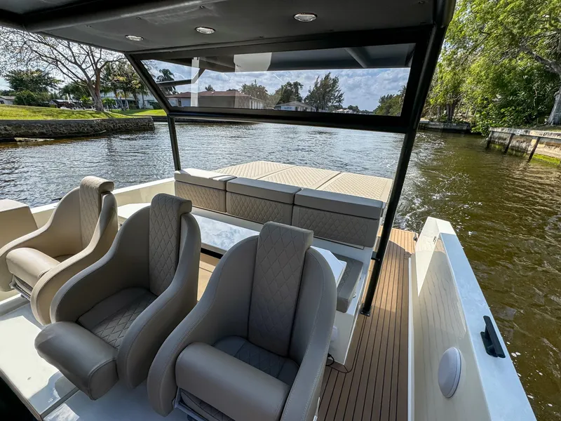 Slide: The Image of 2024 De Antonio Yachts D28 Xplorer interior with luxurious seating on a scenic waterway. - 23