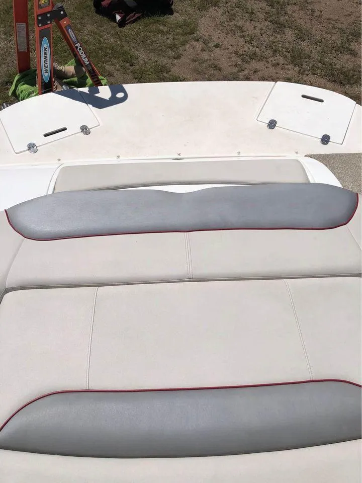 Slide: The Image of 2013 Rinker 246 Captiva Bowrider with beige and gray seating on deck. - 7