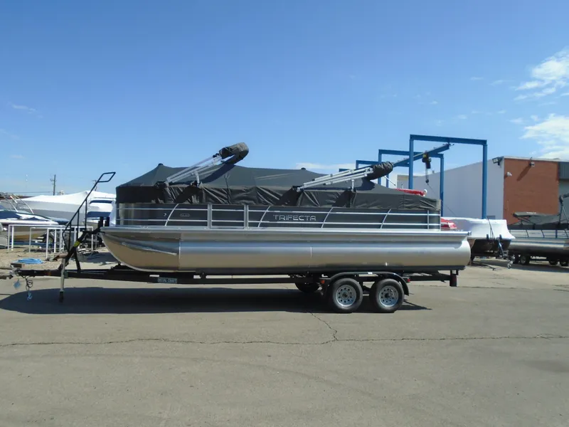 Slide: The Image of 2023 Trifecta 24TRFC LE 2.75 pontoon boat on a trailer in a marina. - 9