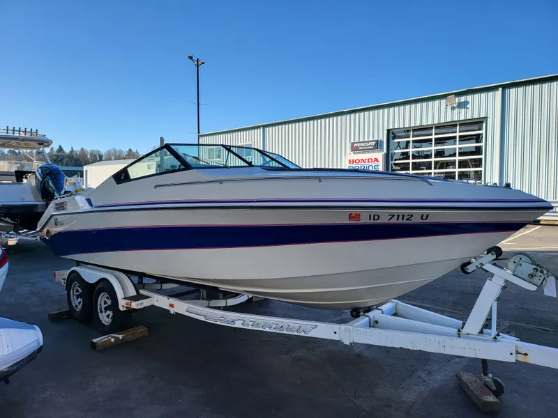 Slide: The Image of 1988 Wellcraft 220 Elite boat on a trailer in a marina. - 11
