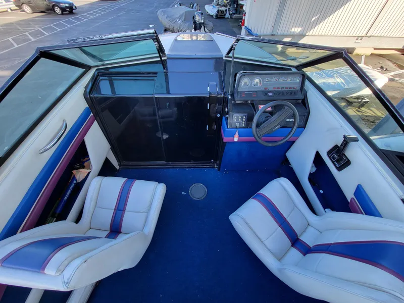 Slide: The Image of 1988 Wellcraft 220 Elite boat interior with blue carpet and white seats. - 3