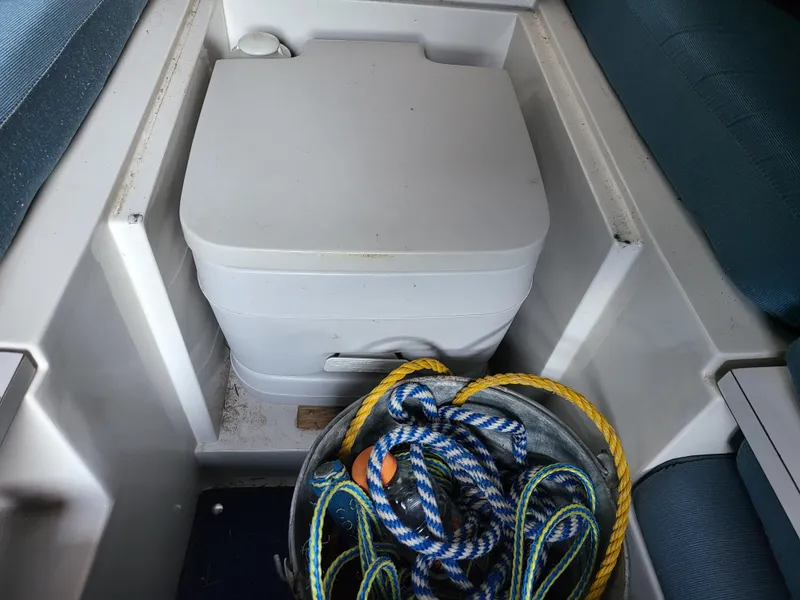 Slide: The Image of Interior of 1988 Wellcraft 220 Elite boat with portable toilet and coiled ropes. - 6