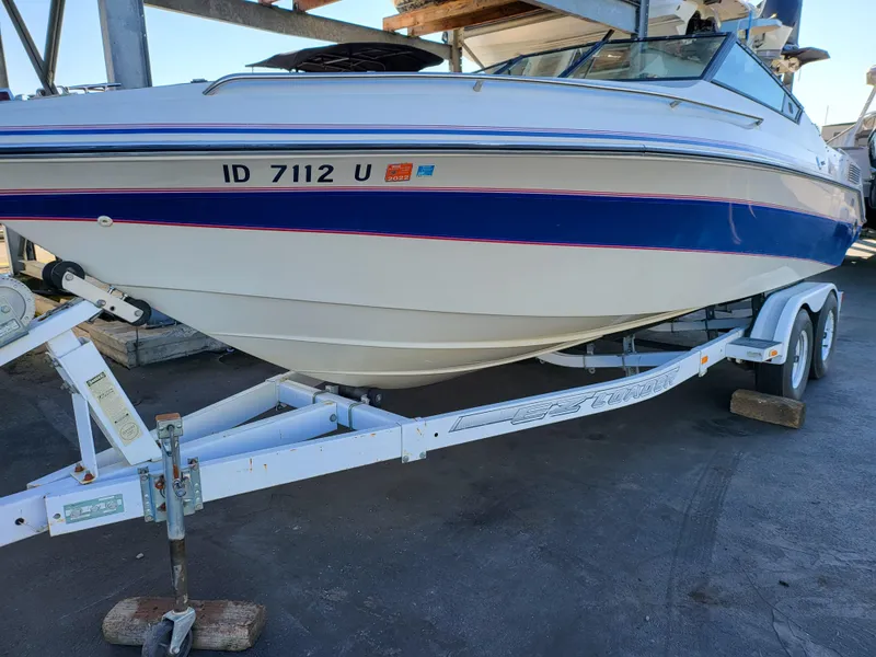 Slide: The Image of 1988 Wellcraft 220 Elite boat on trailer, white with blue and red stripes. - 9
