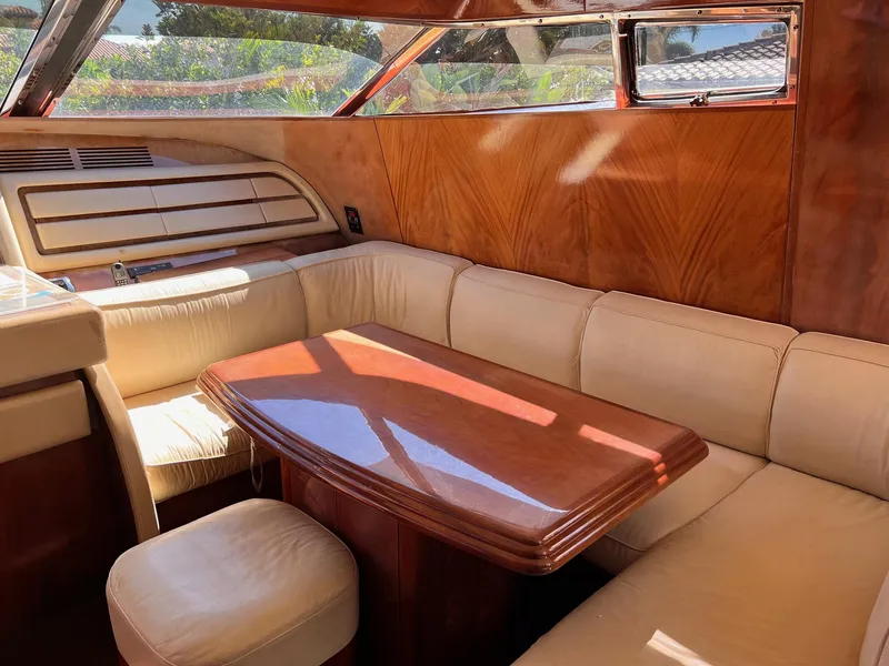 Slide: The Image of Luxurious interior of 2001 Maiora 20 yacht with wooden table and cream seating. - 11