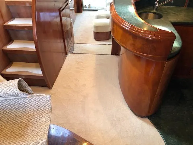 Slide: The Image of Luxurious interior of 2001 Maiora 20 yacht with wooden finishes and carpeted flooring. - 13