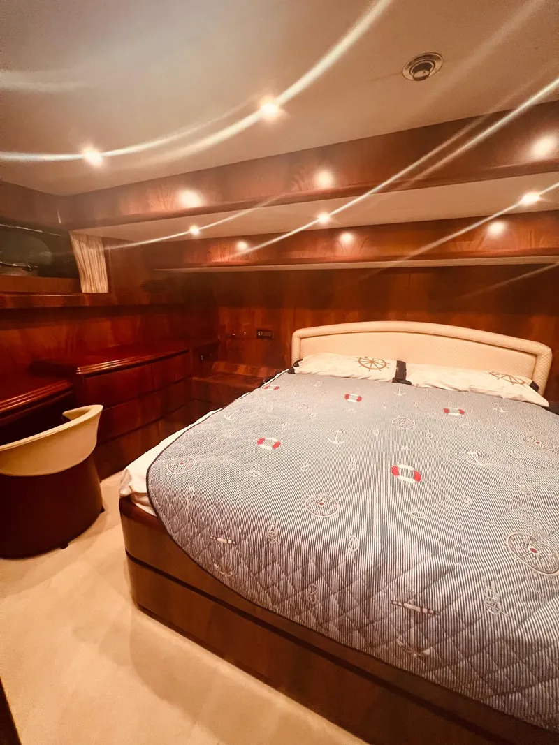 Slide: The Image of Luxurious bedroom on a 2001 Maiora 20 yacht with wood paneling and cozy lighting. - 19