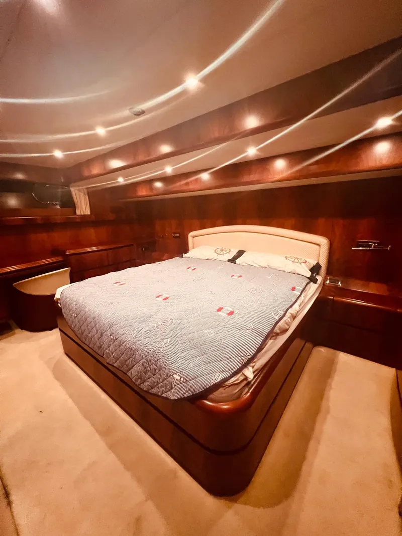 Slide: The Image of Luxurious bedroom on a 2001 Maiora 20 yacht with elegant wood paneling. - 21