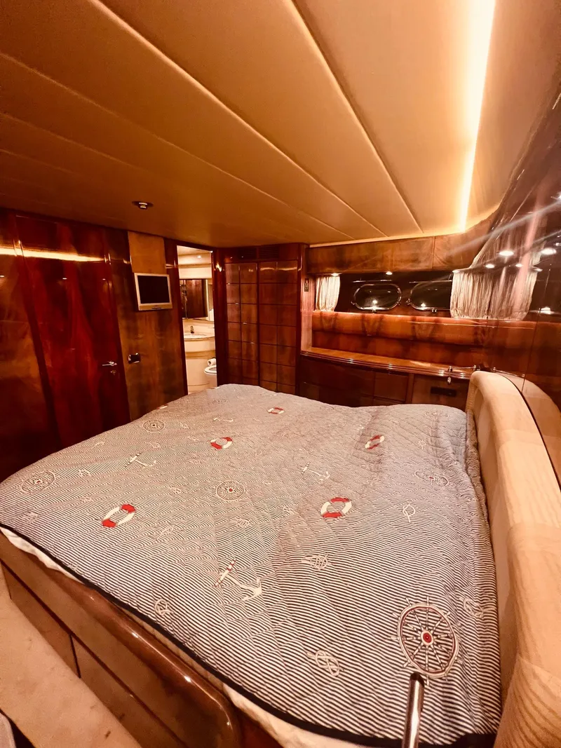 Slide: The Image of Luxurious bedroom interior of 2001 Maiora 20 yacht with wood paneling and cozy lighting. - 24