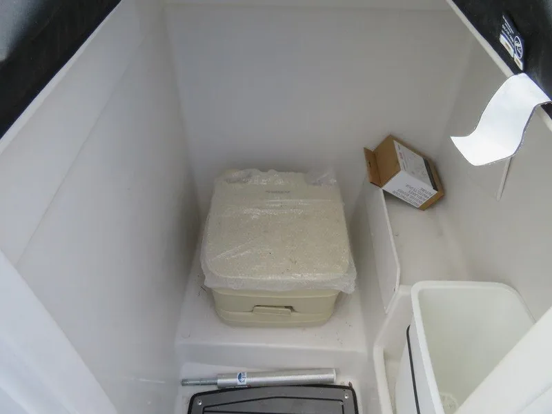 Slide: The Image of Starcraft 231 OB 2022 boat interior storage compartment with portable toilet. - 16