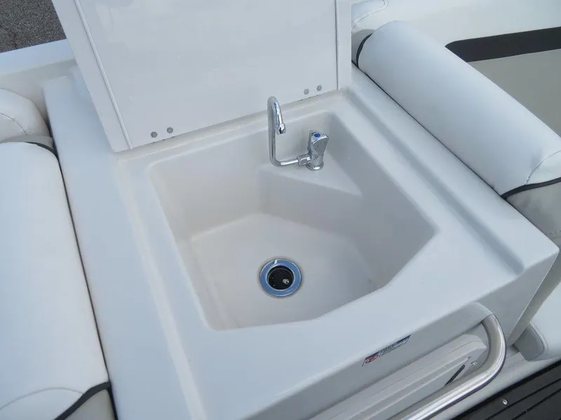 Slide: The Image of 2022 Starcraft 231 OB boat sink with faucet and white cushioned seating. - 17