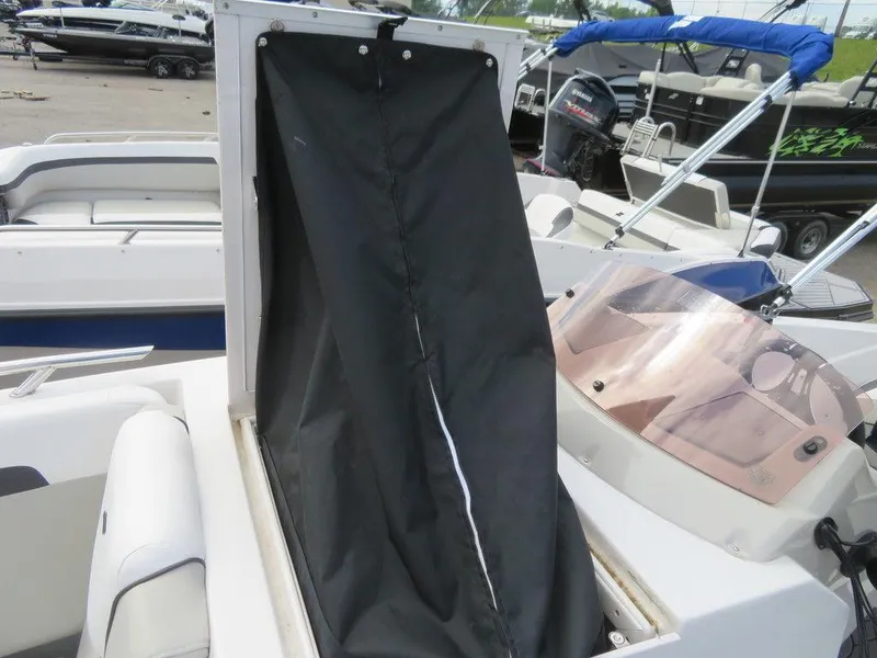 Slide: The Image of 2022 Starcraft 231 OB boat interior with black cover and seating area. - 18