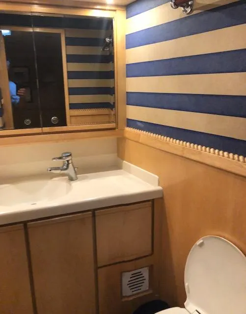Slide: The Image of Bathroom interior of a 1997 Bertram Convertible yacht with striped wallpaper. - 13