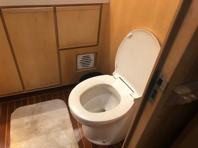 Slide: The Image of 1997 Bertram Convertible bathroom with wooden cabinets and white toilet. - 16