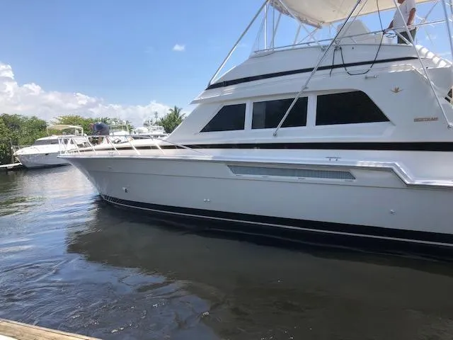 Slide: The Image of 1997 Bertram Convertible yacht docked in a marina on a sunny day. - 2