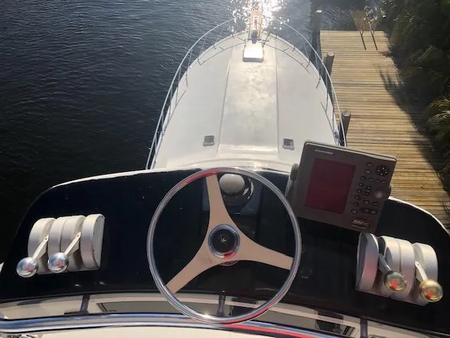 Slide: The Image of 1997 Bertram Convertible boat helm with steering wheel and navigation equipment. - 28