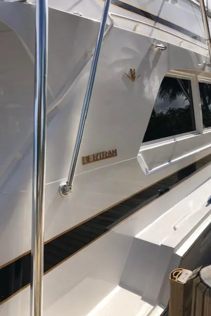 Slide: The Image of 1997 Bertram Convertible yacht docked, side view with logo. - 3
