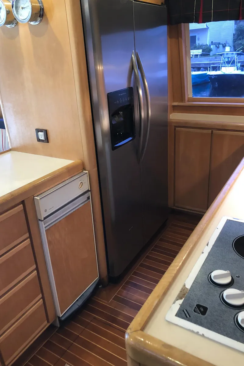 Slide: The Image of 1997 Bertram Convertible kitchen with stainless steel refrigerator and wooden cabinetry. - 9