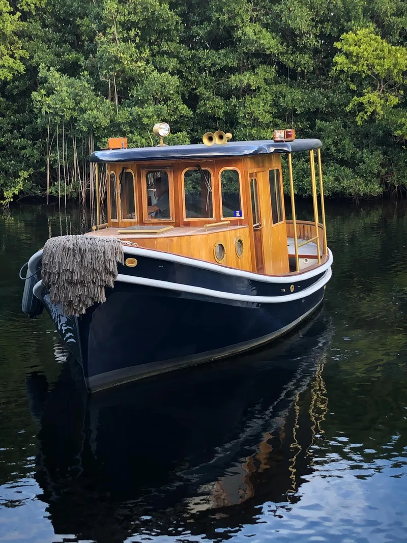 Slide: The Image of 1992 Crosby Tug boat on calm water with lush green background. - 1