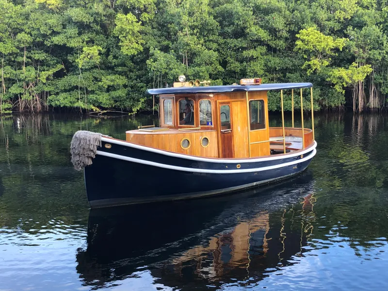 Slide: The Image of 1992 Crosby Tug boat on calm water with lush green trees in the background. - 2