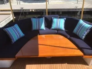 Slide: The Image of 1992 Crosby Tug boat seating area with blue cushions and striped pillows. - 8