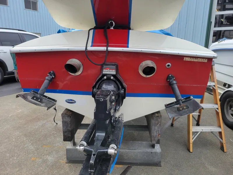 Slide: The Image of 1973 Donzi X18 boat rear view with red and white hull, outdrive, and trim tabs. - 14