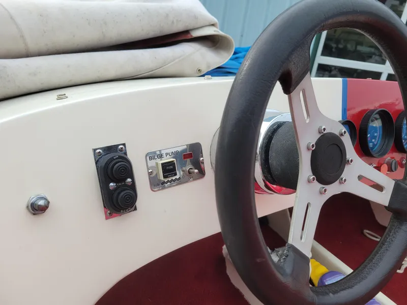 Slide: The Image of 1973 Donzi X18 boat dashboard with steering wheel and bilge pump controls. - 5
