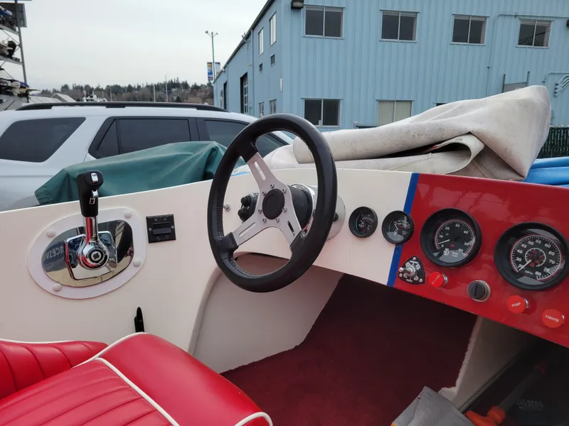 Slide: The Image of 1973 Donzi X18 boat interior with red seats, steering wheel, and dashboard gauges. - 6