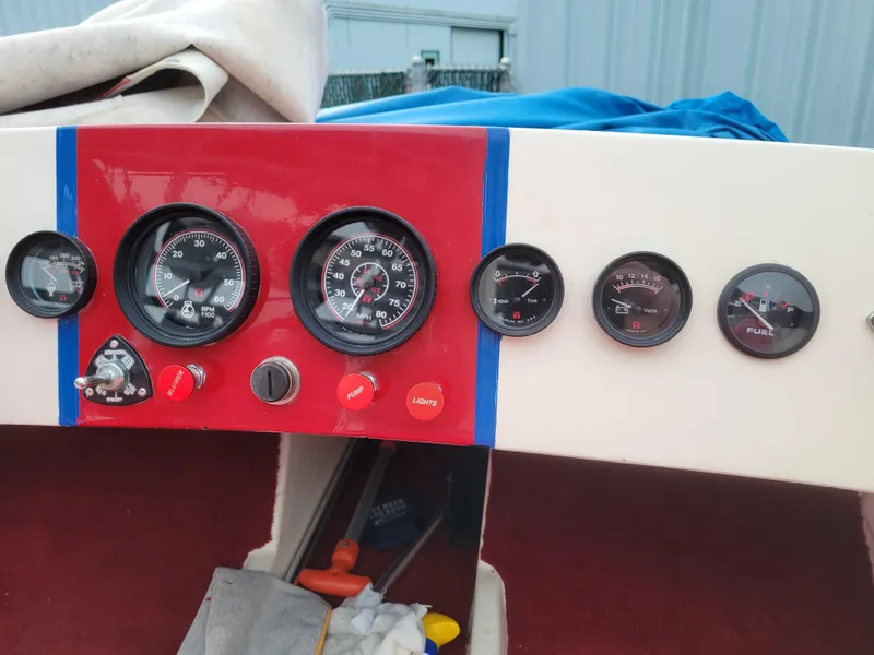 Slide: The Image of 1973 Donzi X18 dashboard with gauges and controls, featuring a red and white design. - 8