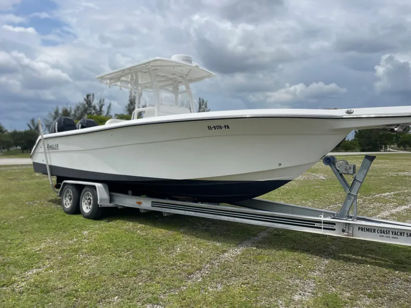 Slide: The Image of 2006 Angler 2900CC boat on a trailer in a grassy area. - 1