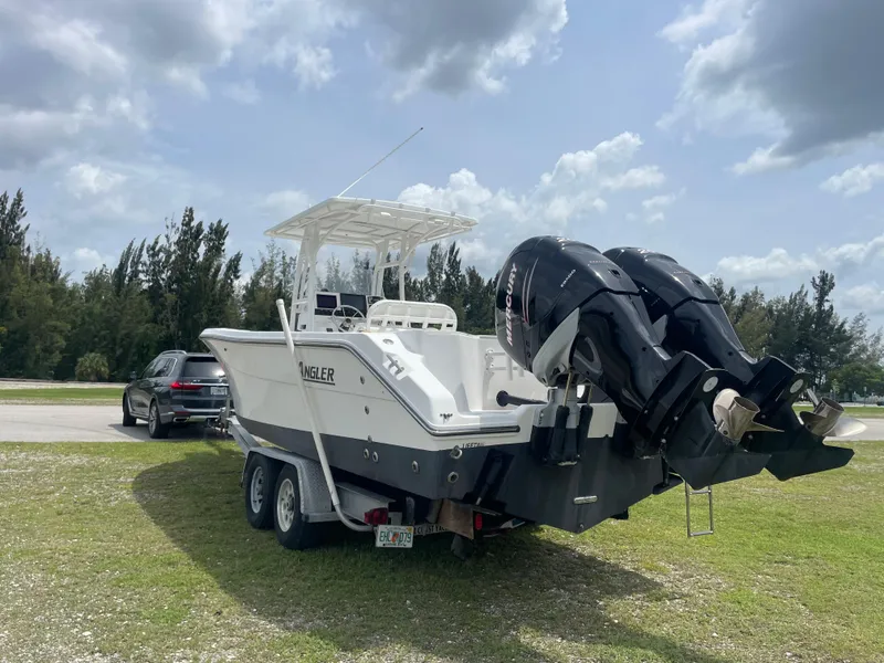 Slide: The Image of 2006 Angler 2900CC boat on a trailer with dual outboard motors. - 10