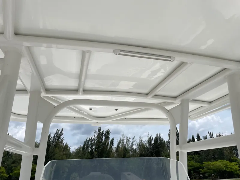 Slide: The Image of 2006 Angler 2900CC boat T-top with white frame and clear sky background. - 19