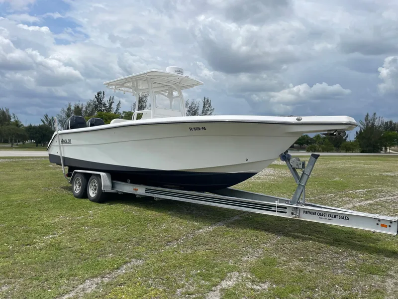 Slide: The Image of 2006 Angler 2900CC boat on trailer under cloudy sky. - 2
