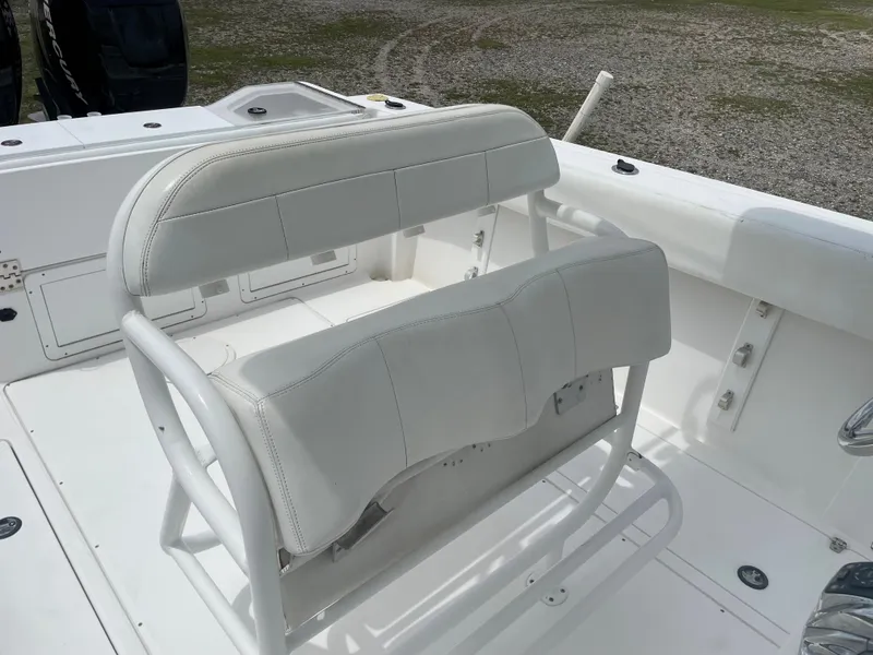 Slide: The Image of 2006 Angler 2900CC boat with white cushioned seating and storage compartments. - 20