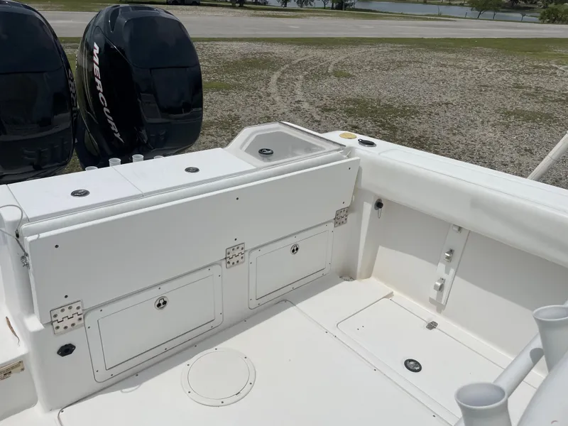 Slide: The Image of 2006 Angler 2900CC boat deck with storage compartments and twin Mercury engines. - 23