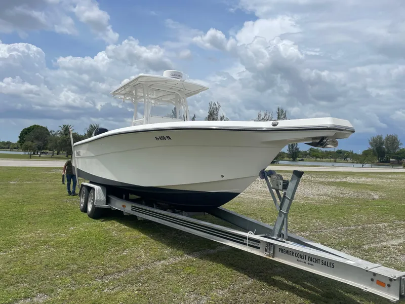 Slide: The Image of 2006 Angler 2900CC boat on trailer in grassy area under cloudy sky. - 3