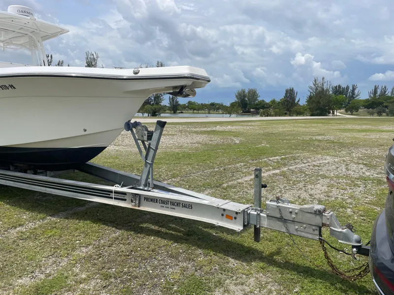 Slide: The Image of 2006 Angler 2900CC boat on trailer in grassy area under cloudy sky. - 5