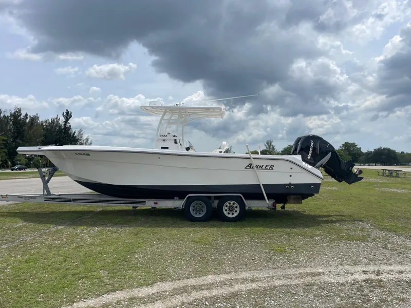 Slide: The Image of 2006 Angler 2900CC boat on a trailer under cloudy sky. - 7