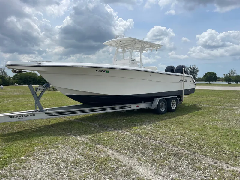 Slide: The Image of 2006 Angler 2900CC boat on a trailer under a cloudy sky. - 8