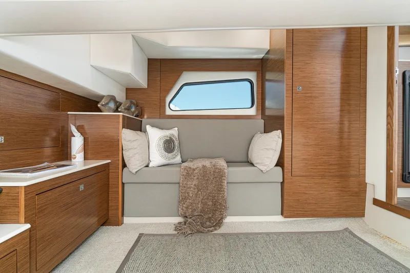 Slide: The Image of 2017 Cruisers Yachts 390 Express Coupe interior with cozy seating area and modern wood finishes. - 33