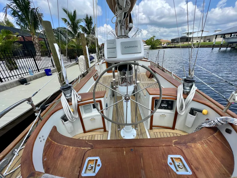 Slide: The Image of 1986 Cherubini 44 sailboat cockpit with Garmin navigation, docked by the water. - 23